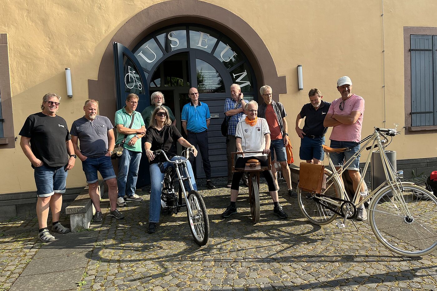Aktive des ADFC Mainz-Bingen vor dem Rheinhessischen Fahrradmuseum in Gaul-Algesheim beim Testen historischer Räder
