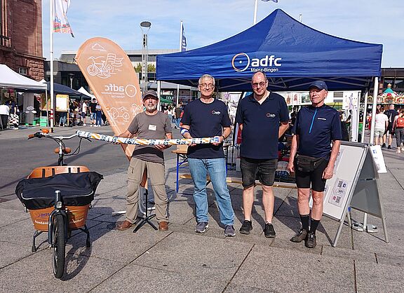 Unsere Aktive vor dem Infostand, mit einer 1,5 m langen Schwimmnudel - diesen Abstand müssen Autofahrer innerorts beim Überholen von Radfahrenden einhalten