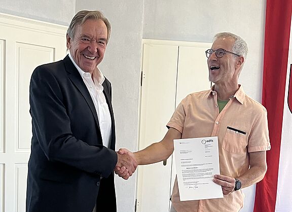 Andreas Schmitt (rechts) übergibt das Gratulationsschreiben an den Museumsleiter, Emil Busch )