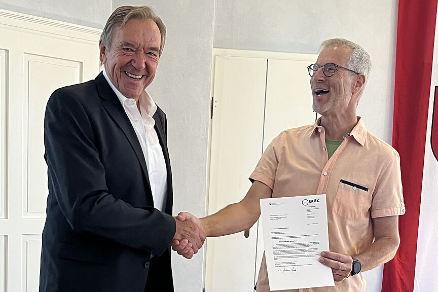 2025-08-07_UEbergabeGratulationsschreiben_RheinhessischesFahrradmuseum.jpg Andreas Schmitt (rechts) übergibt das Gratulationsschreiben an den Museumsleiter, Emil Busch )