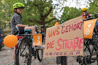 Kind mit Fahrrad und Protestschild